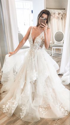 a woman is taking a selfie in her wedding dress while holding a cell phone