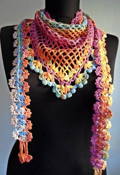 a mannequin wearing a multicolored crocheted scarf on it's neck