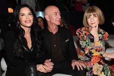 three people sitting next to each other at an event