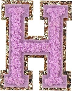 the letter h is made up of purple and gold glittered letters with flowers on them