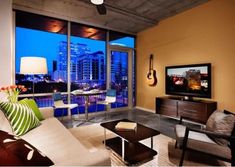 a living room filled with furniture and a flat screen tv sitting on top of a wall