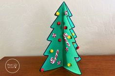 an origami christmas tree with candy canes and candies on the top