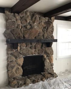 a stone fireplace is being installed in the living room