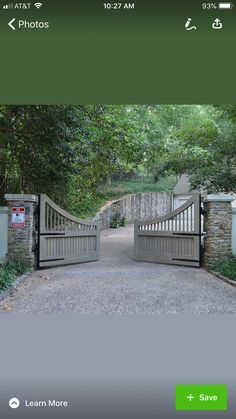 an image of a gated driveway with trees on either side and the entrance to it