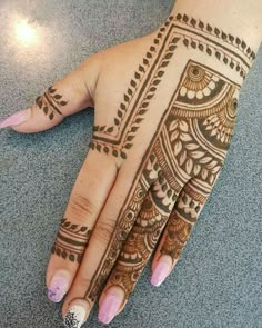 a woman's hand with henna tattoos on it