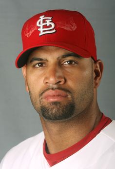 a close up of a baseball player wearing a red hat