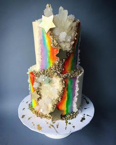 a three tiered cake decorated with rainbows and stars