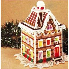 a crocheted gingerbread house ornament on a doily