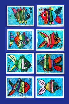 four different colored fish paintings on blue paper