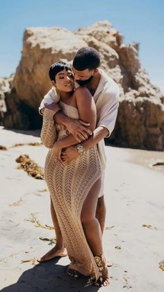 a man and woman hugging on the beach