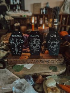 two black wooden signs sitting on top of a table next to rocks and other items