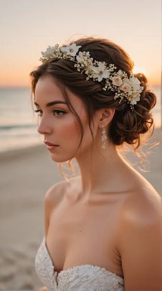 a woman in a wedding dress on the beach at sunset wearing a flower headpiece