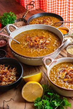 several bowls of soup on a table with lemons, parsley and other ingredients