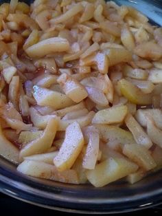 a bowl filled with sliced apples on top of a stove