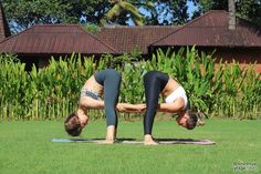 two women are doing yoga in the grass