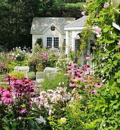 a house surrounded by flowers and greenery next to a garden with chairs in the foreground