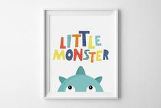 a framed poster with the words little monster in multicolored letters on it's face