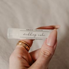 a person holding a wedding cake tube in their hand