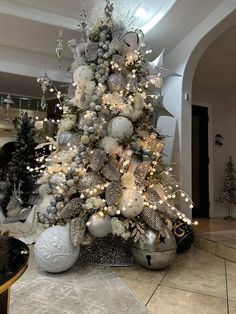 a decorated christmas tree with silver and white ornaments