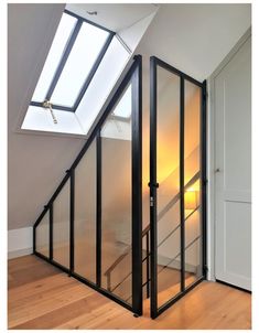 an empty room with glass walls and wooden flooring is seen in this image from the bottom level