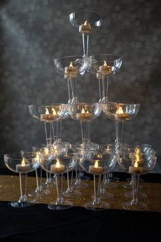 many wine glasses with candles in them are arranged on top of each other and placed together