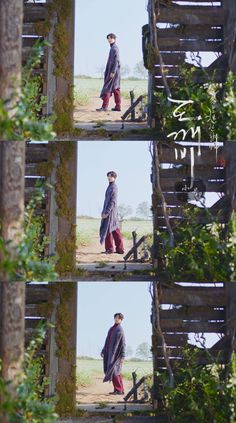 two men walking down a dirt road next to a wooden fence