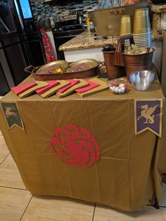 a table covered in brown paper with red and purple decorations on it, sitting next to a refrigerator