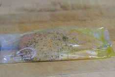 a piece of chicken in a plastic bag on a wooden table