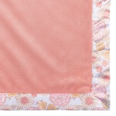 a pink and white blanket with flowers on it