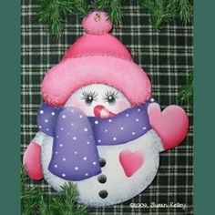 a painting of a snowman with a pink hat and scarf on it's face