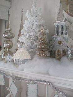 a white mantle topped with lots of christmas trees and snow covered houses on top of it