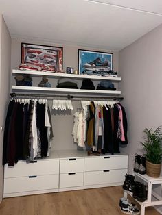 an organized closet with clothes hanging on the shelves and shoes sitting on top of it