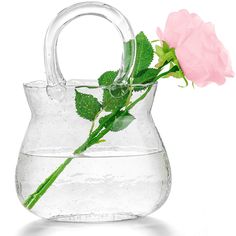 a pink rose in a clear vase with water and ice on the bottom that is filled with water