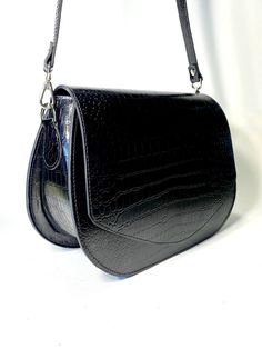 This saddle bag, like all the others, uses our original ideas and handicrafts  Stylish modern lady's bag🔥 Suitable for any outfit from jeans to evening gowns. 👗 Made from genuine Italian leather with embossed crocodile 🐊 . A very beautiful and popular color is black. ❤ Inside from eco-leather. 🔺Type: saddle bag, crossbody bag, shoulder bag 🔺Size: 24 * 18 * 9cm (9,5x7,1x3,54 inches) 🔺Belt Length: 120cm (47,25 inch) This model can be made in different colors of genuine leather.🌈 Lightweight Luxury Formal Saddle Bag With Bill Compartment, Luxury Black Saddle Bag With Palladium Hardware, Luxury Modern Saddle Bag With Turn-lock Closure, Luxury Black Saddle Bag For Office, Trendy Luxury Rectangular Saddle Bag, Luxury Formal Saddle Bag Crossbody, Luxury Formal Saddle Crossbody Bag, Luxury Saddle Shoulder Bag For Formal Occasions, Luxury Evening Crossbody Saddle Bag