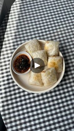 a white plate topped with food on top of a checkered table cloth