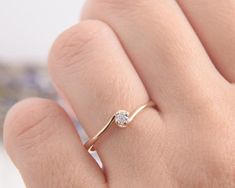 a woman's hand with a diamond ring on top of her finger, showing the side view