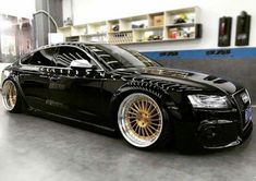 a black car with gold rims parked in a garage