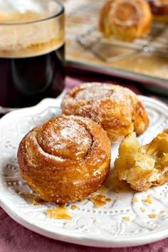 two pastries on a plate next to a cup of coffee