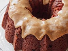 a chocolate bundt cake with frosting on a glass plate