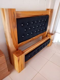 a bed frame made out of wood and black fabric