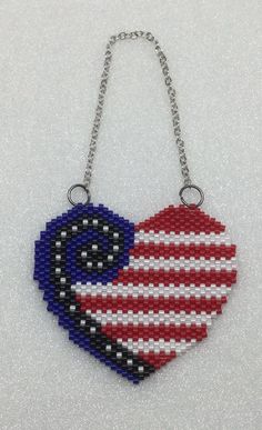 a heart shaped beaded necklace with the american flag painted on it's side