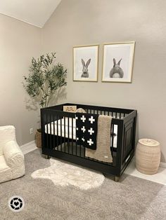 a baby crib with two pictures on the wall