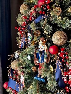 a christmas tree with ornaments on it and decorations hanging from the top, including a nutcracker ornament