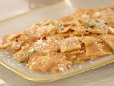 pasta with sauce and parmesan cheese in a glass dish on a counter top