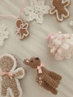 crocheted teddy bears and other decorations on a white tablecloth with snowflakes