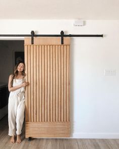 a woman standing in front of a sliding door with her hand on the side of it