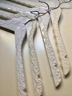 five pieces of white lace hang on a table