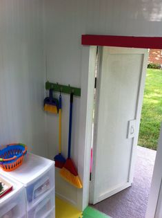 the inside of a house with tools and cleaning supplies on the floor, including brooms and mop's