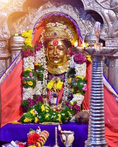 there is a statue with flowers on it in the middle of a shrine, surrounded by other items