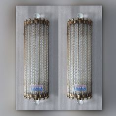 two metal wall sconces with glass balls and chains attached to the sides of them